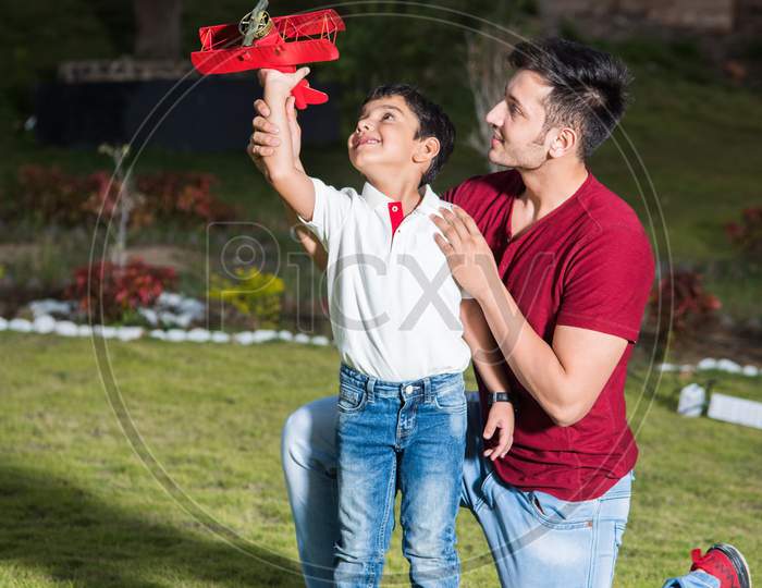 Indian father and son with toy plane, outdoor