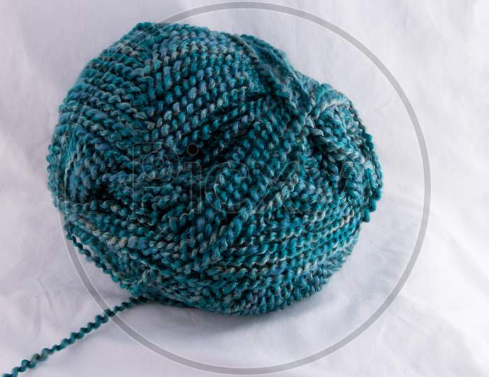 Multi Blue Tones Of Spiral Twisted Yarn Ball With Strand Leading To Left