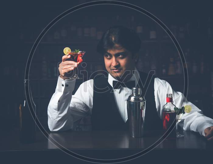 Indian/Asian Bartender making  cocktail in restaurant