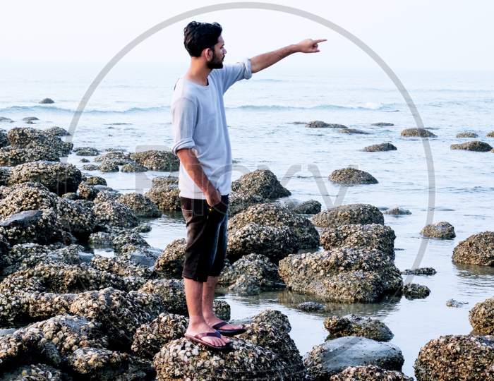 A Young Man Indicate At Deep Sea During Watching The Beauty Of Coral Sea Beach .