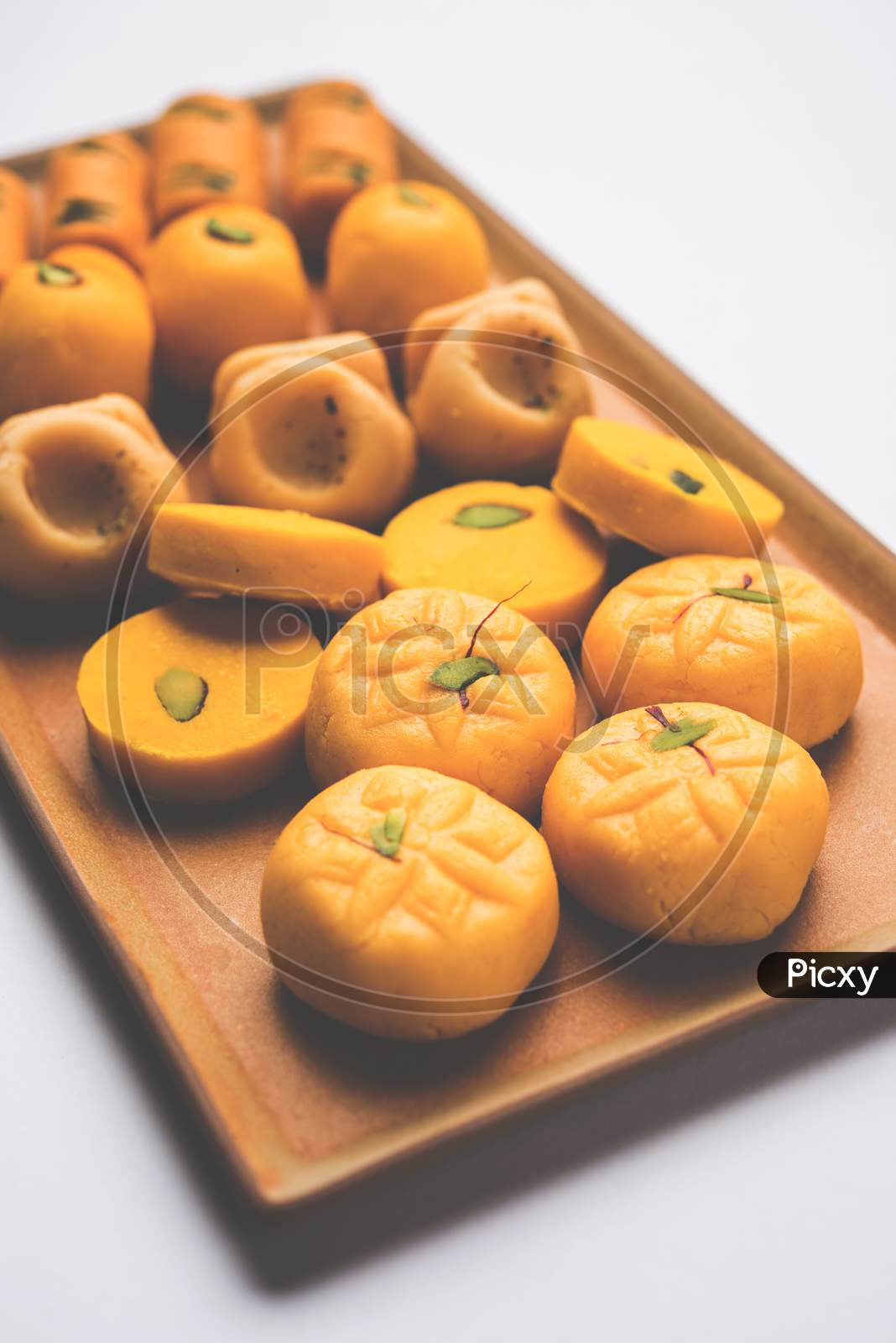 variety of sweets or orange peda or pedha or pera made up of milk, khoya, sugar , saffron etc