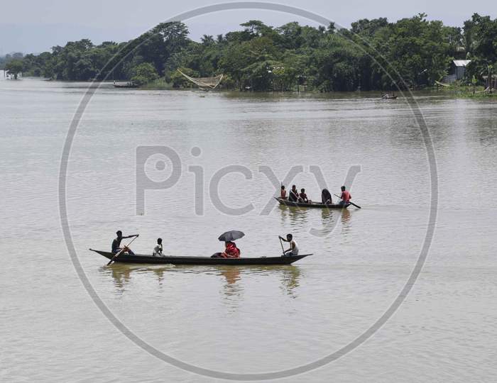Villagers cross a flooded area on a boat