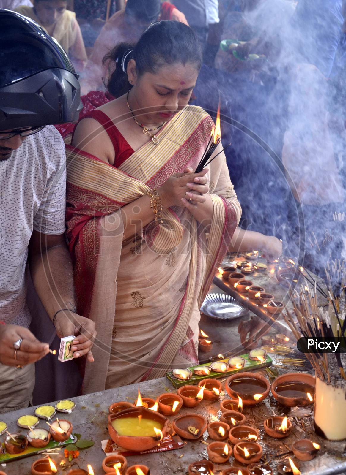 Devotees lighting  the earthen lamp to offer prayers to Lord Ganesha
