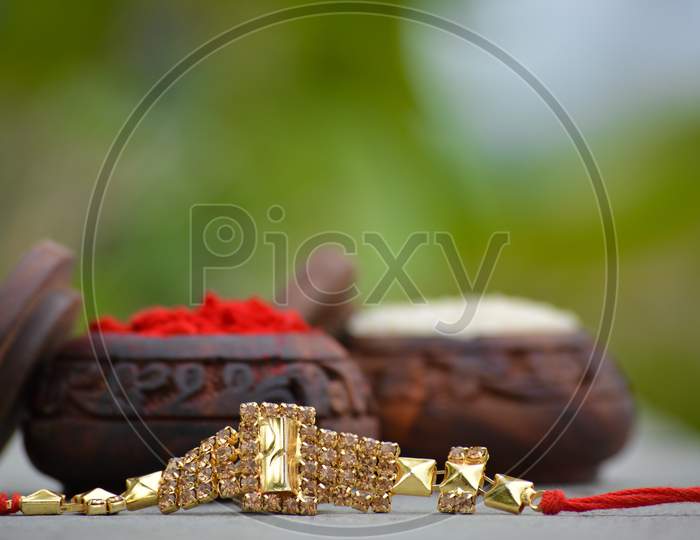 Raksha bandhan rakhi with rice grains and kumkum. A traditional indian wrist band which is a symbol of love between Brothers and Sisters
