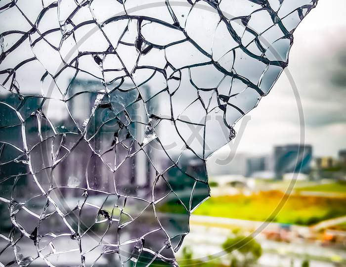 Closeup View From Broken Window. Shattered Window Glass. City View From Broken Window.
