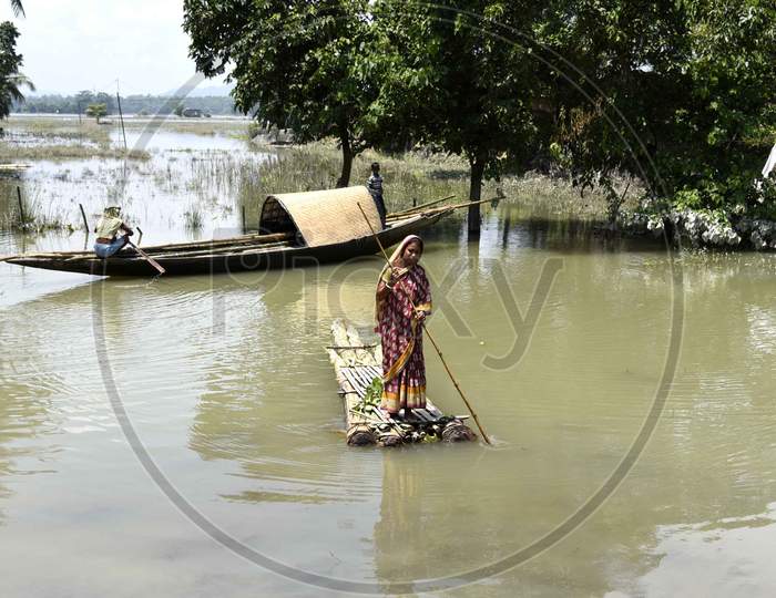 A woman cross a flooded area on a make-shift raft,