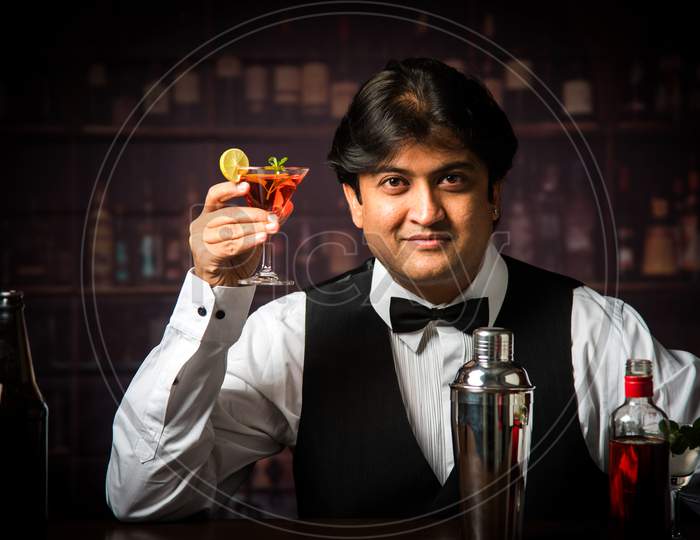 Indian/Asian Bartender making  cocktail in restaurant