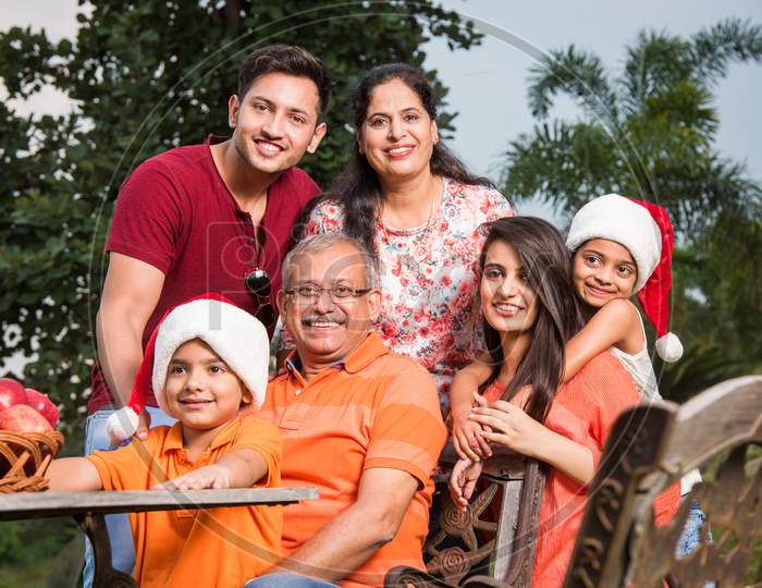 Indian family sitting outdoor and celebrating christmas