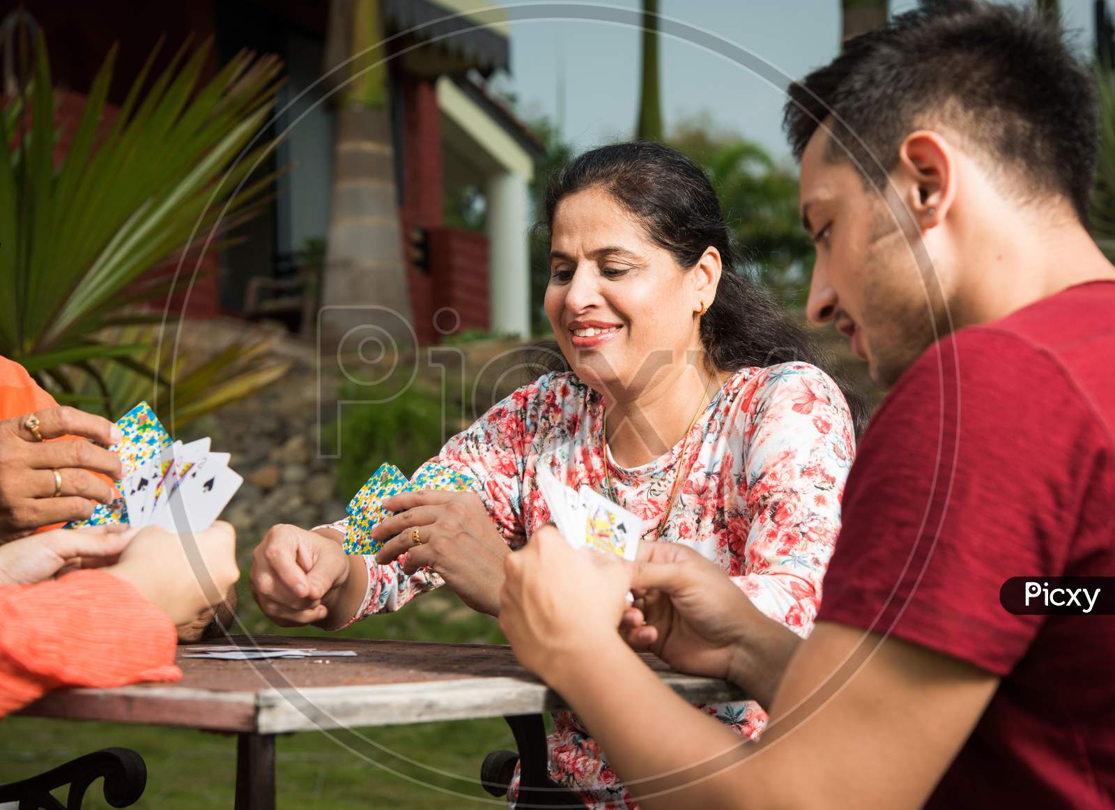 Indian family playing cards while sitting outdoor