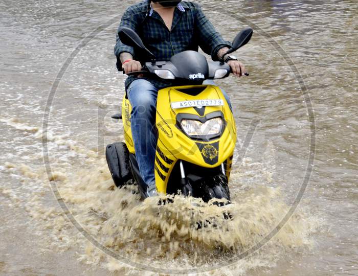 A Scooters  wades through a waterlogged street