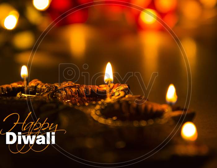 Happy Diwali Greeting Card showing Illuminated diya and bokeh