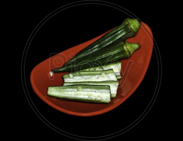 Red Plate of Lady Finger seed on Center Isolated in black background