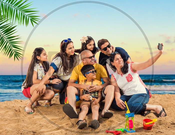 Indian/Asian Family enjoying at beach, posing for picture