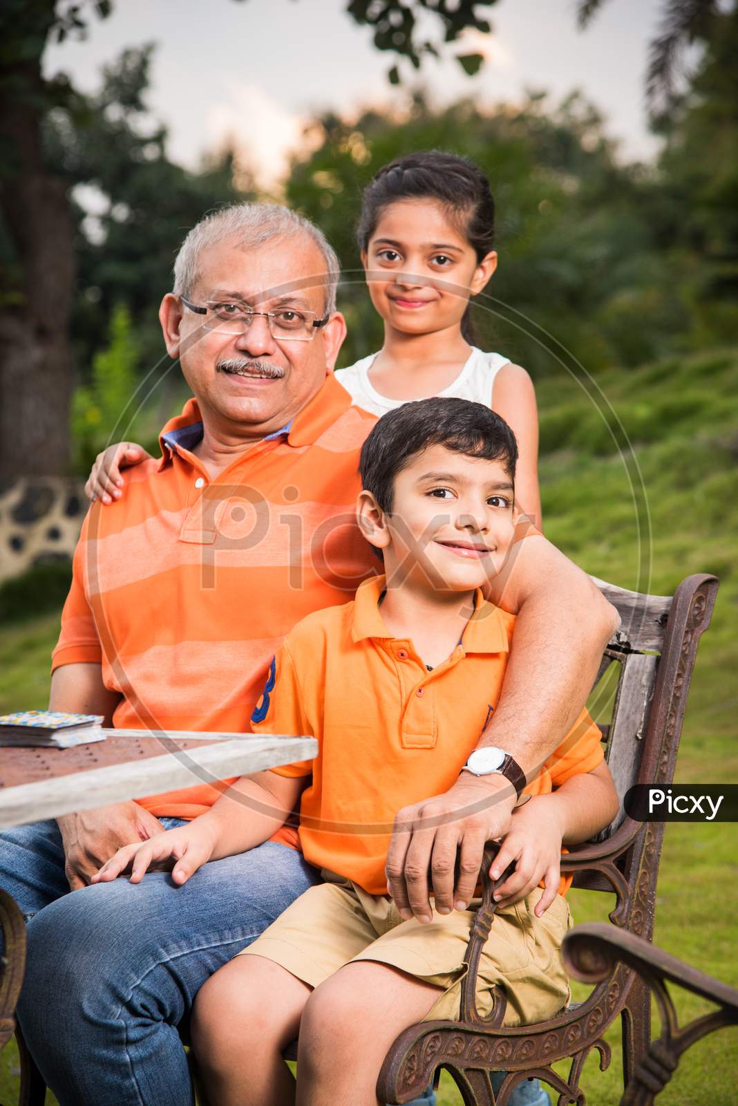 Portrait of Happy Indian/Asian Kids and grandfather sitting on lawn chair