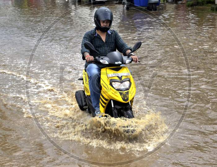 A Scooters  wades through a waterlogged street