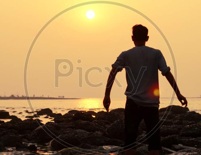 A Young Happy Man Enjoying The Sunset At Coral Sea Beach .