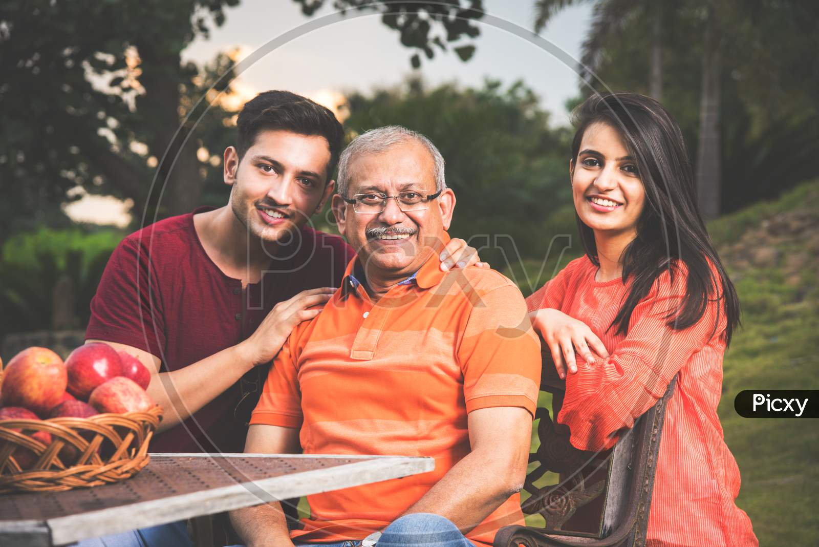 Portrait of Happy Indian/Asian Family while sitting on Lawn chair, outdoor