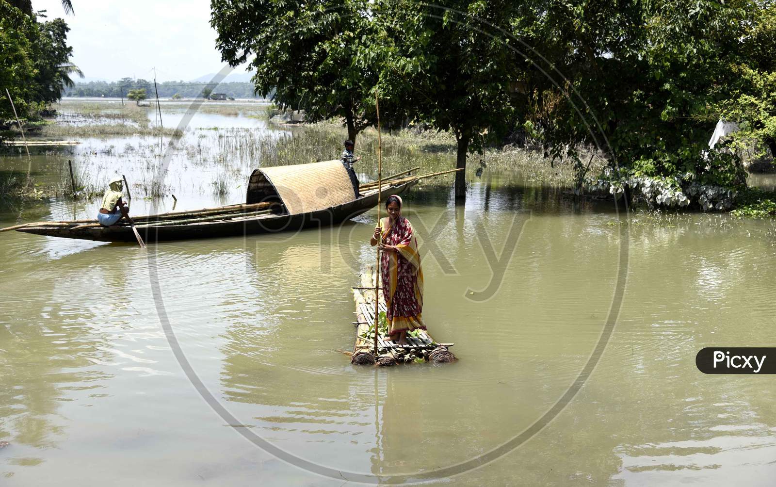 A woman cross a flooded area on a make-shift raft,