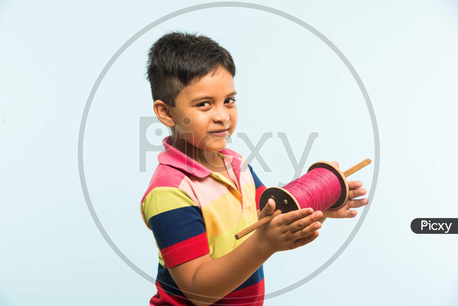 Indian boy holding fikri / spindal / reel on makar sankranti