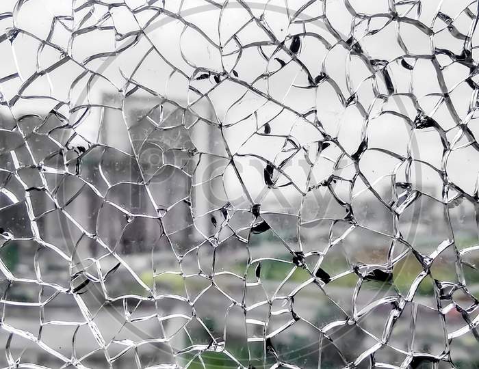 Broken Glass Window. Closeup View From Broken Window. Shattered Window Glass. City View From Broken Window.