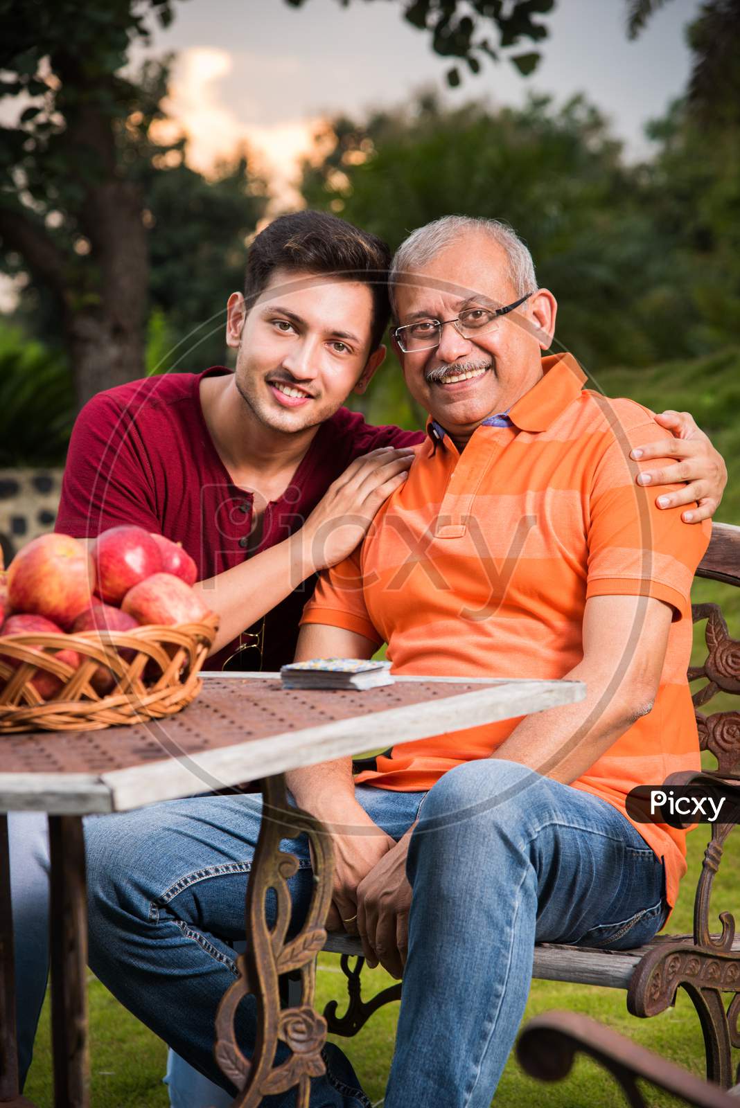 Portrait of Happy Indian/Asian Father and son sitting on lawn chair