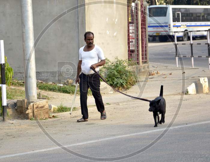 A man along with his pet walking on a deserted road