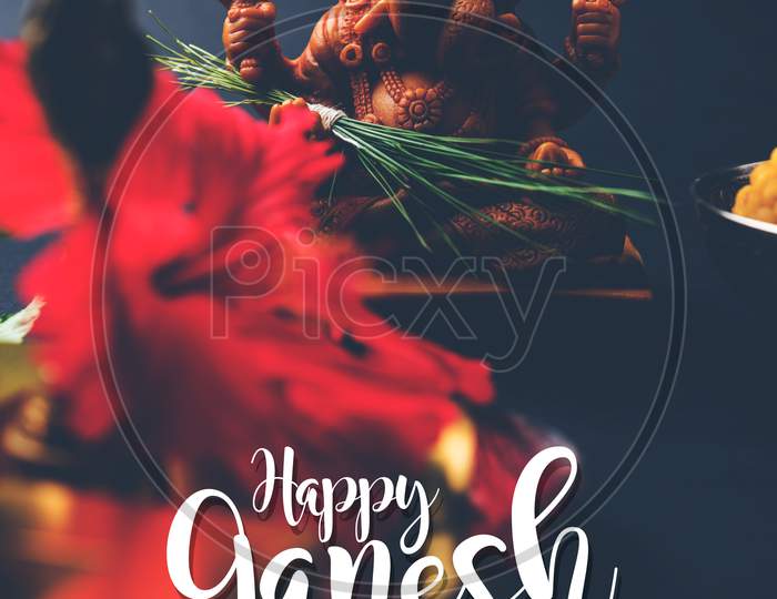 Happy Ganesh Chaturthi Greeting Card showing photograph of lord ganesha idol with pooja or puja thali, bundi laddu/modak, durva