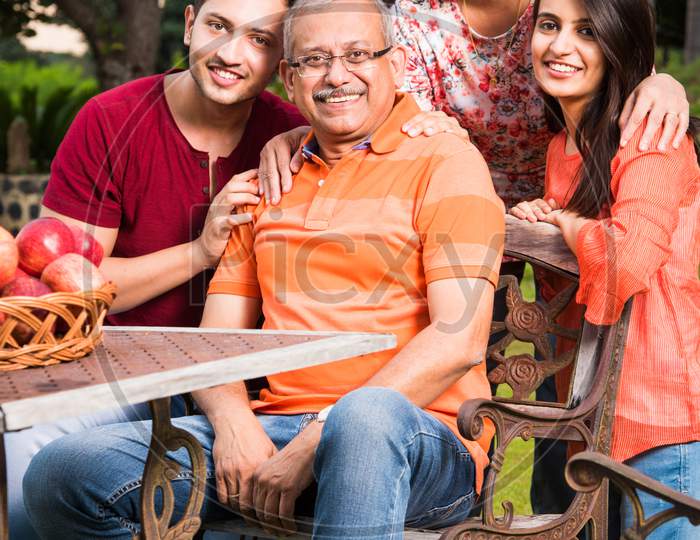 Portrait of Happy Indian/Asian Family while sitting on Lawn chair, outdoor