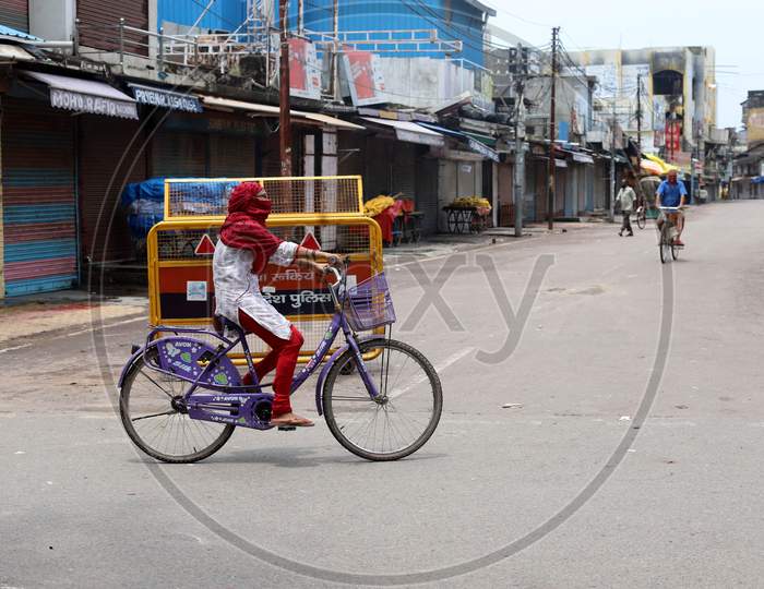 A woman cycles on an empty road during the lockdown in Prayagraj, Uttar Pradesh on July 11, 2020