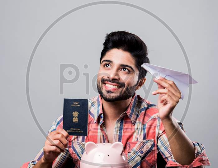 Piggy Bank, Passport and flight - Indian man with money box and paper plane, showing saving and foreign tour concept