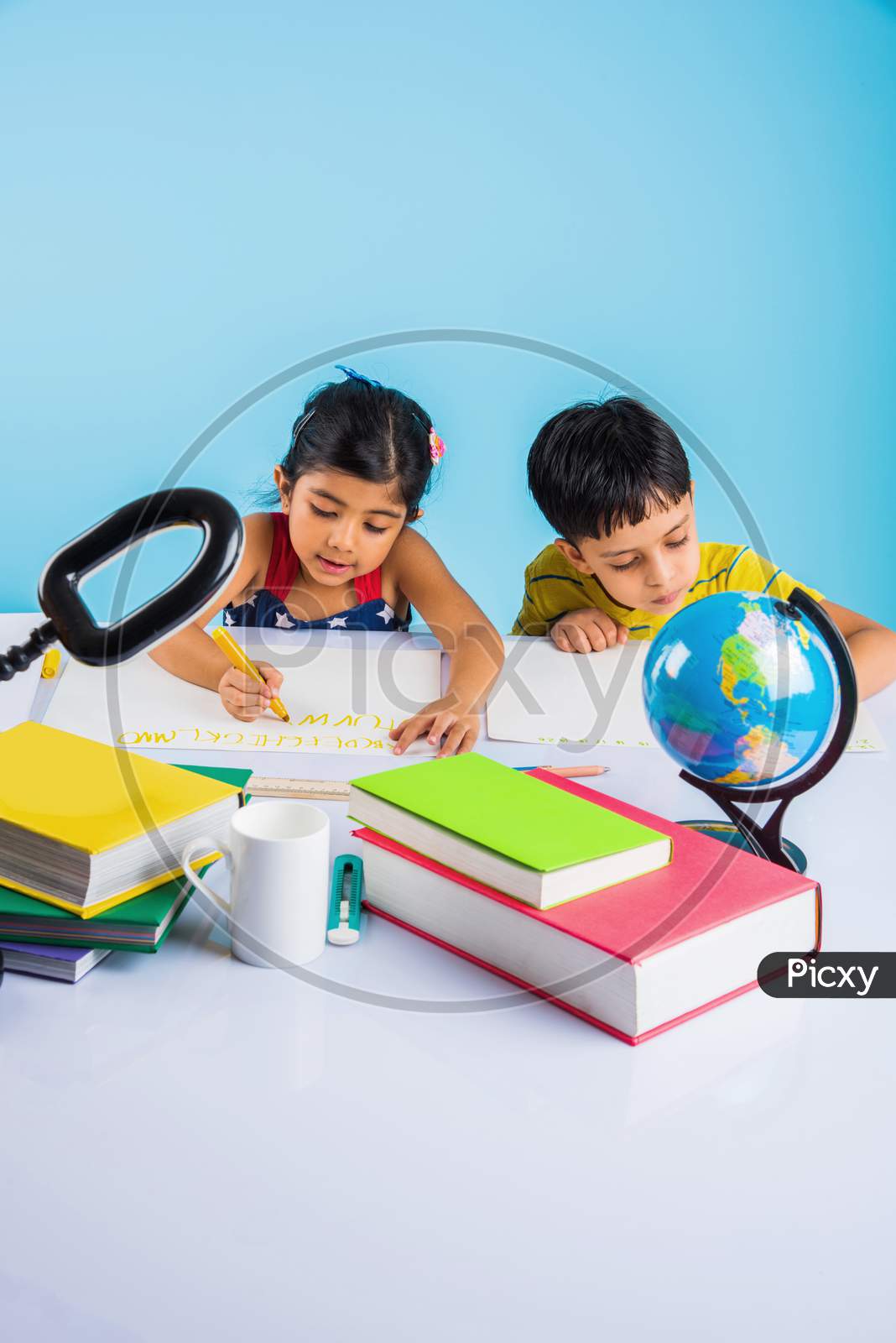Indian school kids/siblings studying at home with books