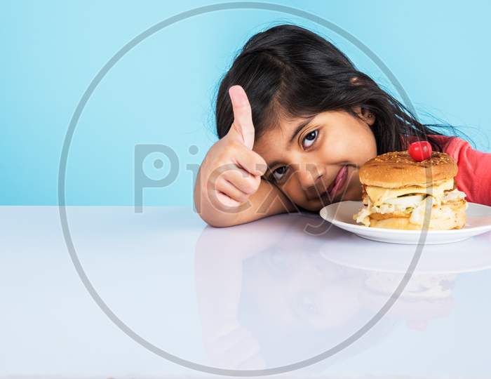 Cute little girl eating burger