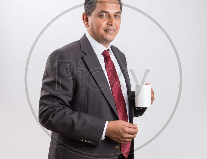 Indian handsome Businessman having coffee / tea / hot drink