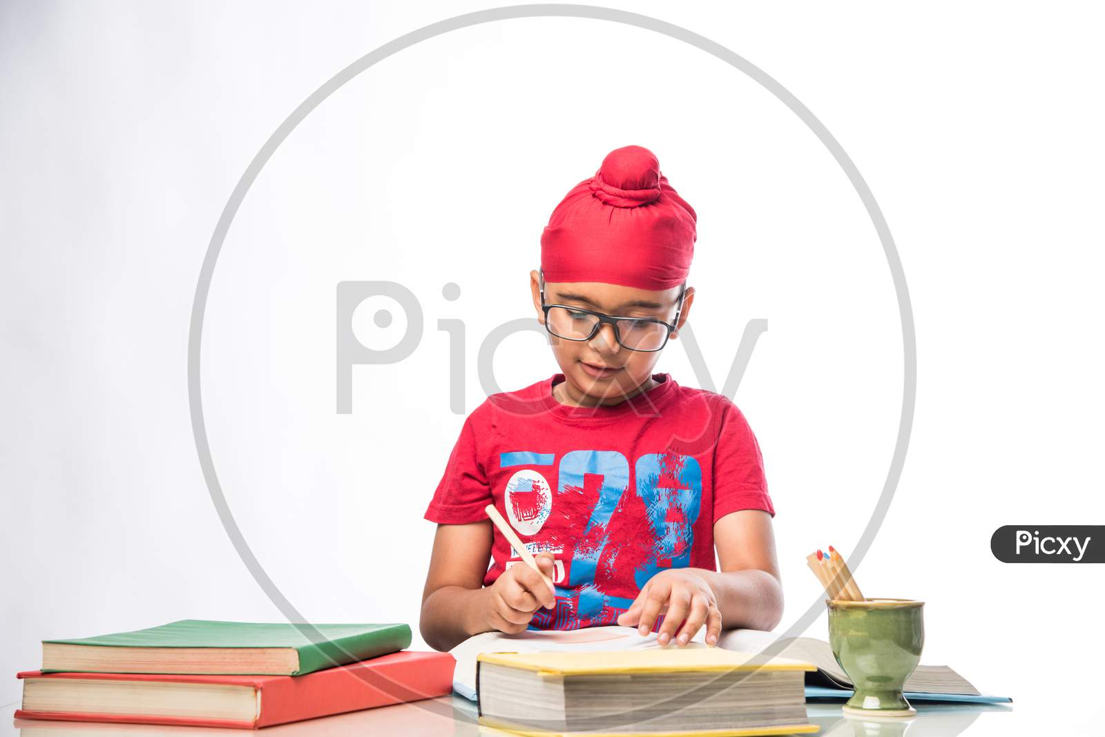 Indian Sikh/punjabi little boy studying with books at study table