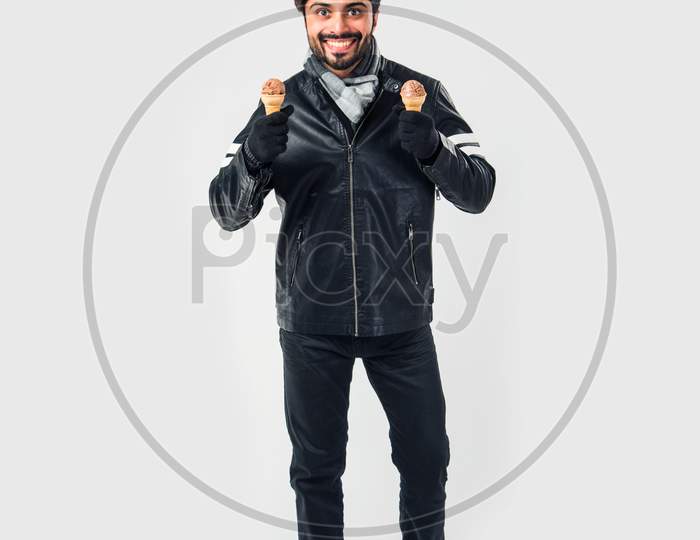 Indian man eating Ice Cream in warm clothes on white background