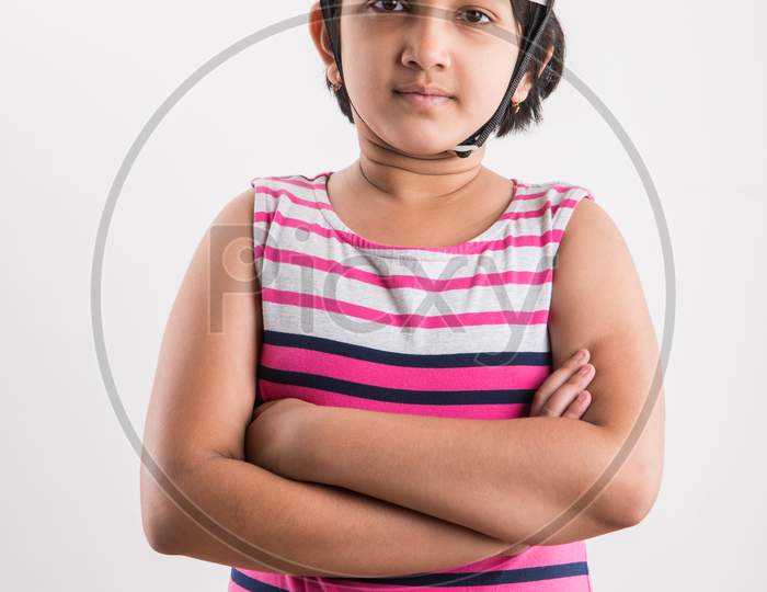 Indian small girl want to be an architect / engineer, wearing Yellow Hard Hat and holding paper drawing Roll