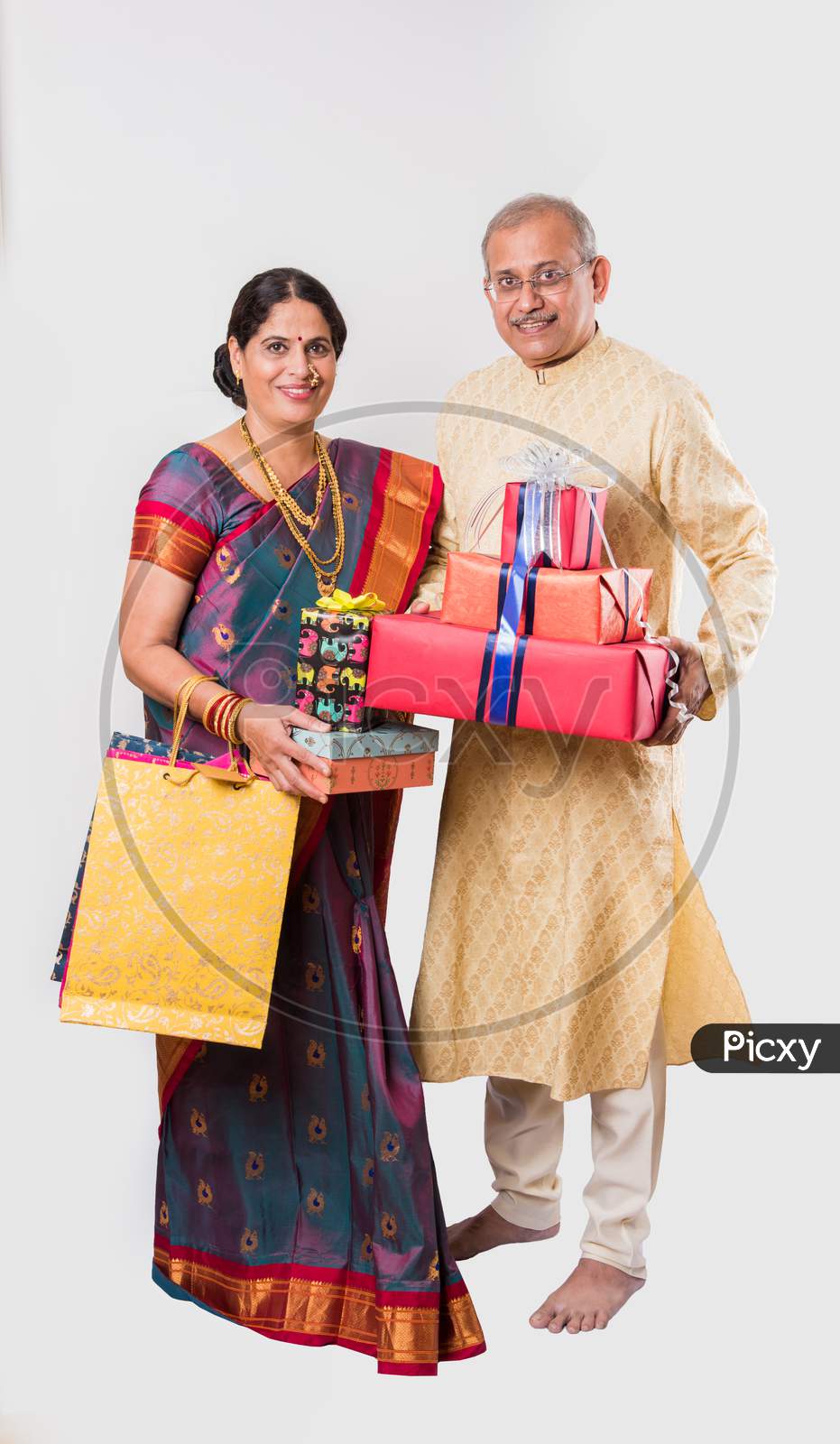 Indian senior / old  couple holding gift boxes