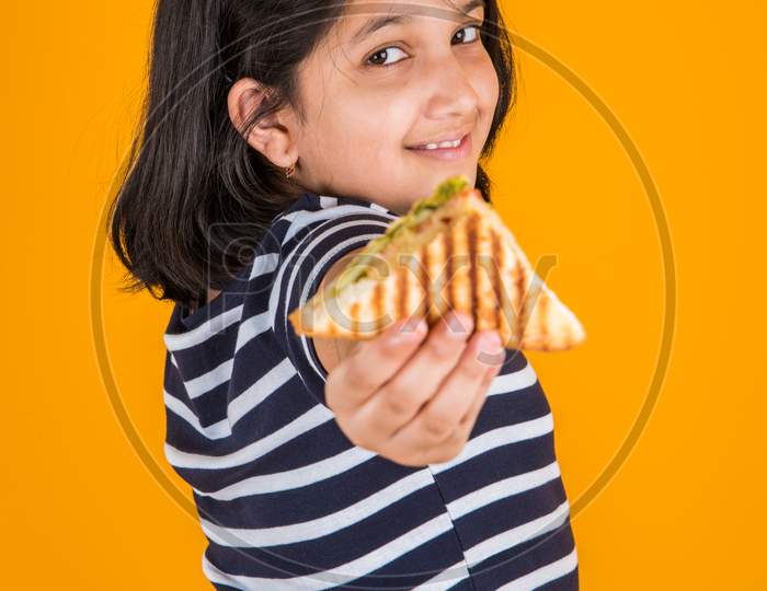 Cute little girl eating sandwich