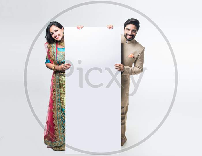 Indian couple holding white board or placard