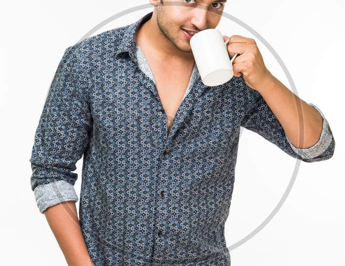 Young man having hot tea/coffee in a mug
