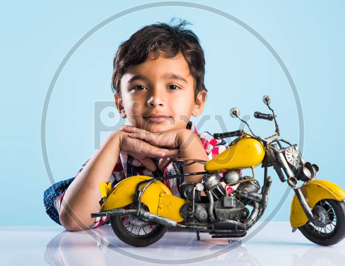 cute little kid mechanic trying to fit toy motor bike