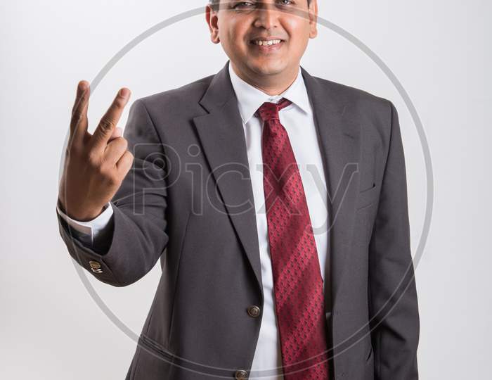 portrait of Indian handsome Businessman showing success / victory / thumbs up