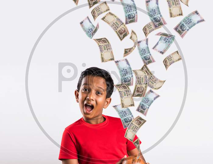 Indian kid catching falling currency notes