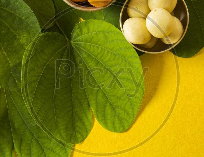 Happy Dussehra greeting card using apta  / Bauhinia racemosa / Bidi leaf with sweet pedha / peda / pera