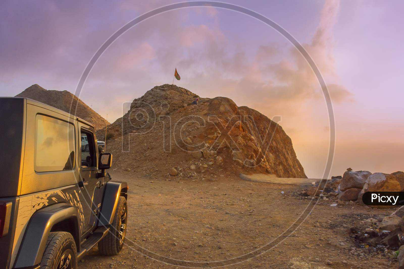 Evening sunset in the mountains of Oman with a vehicle parked for a traveler or trekker.