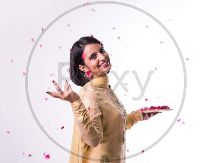 Girl holding a plate full of Rose flower / petals