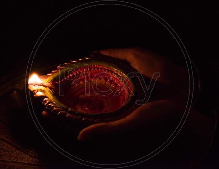 Hand holding diwali diya, closeup