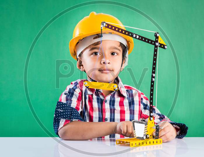 Cute little indian boy playing with toy crane