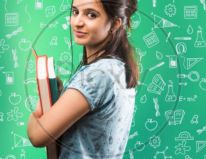 Indian/asian attractive female student with holding piggy bank and books