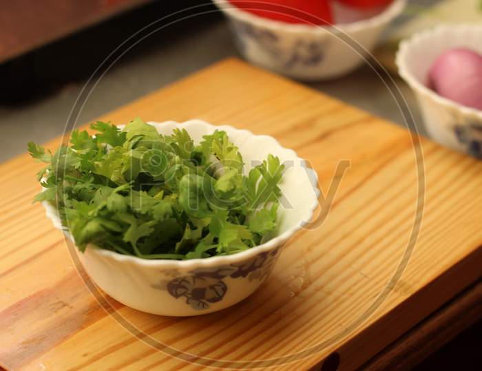 Coriander leaves on a white bowl.